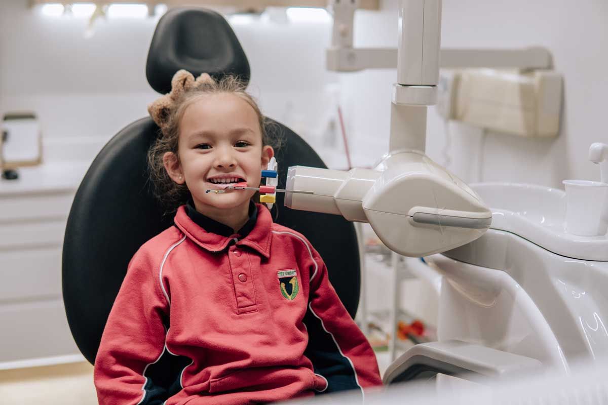 Dentista examinando la boca de un paciente para detectar problemas de caries.